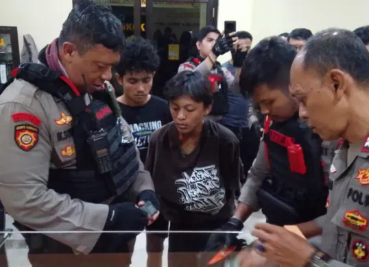 Polisi menyerahkan kedua pelaku dan barang bukti narkoba sinte ke Polsek Sukmajaya. (Sumber: Polres Metro Depok)