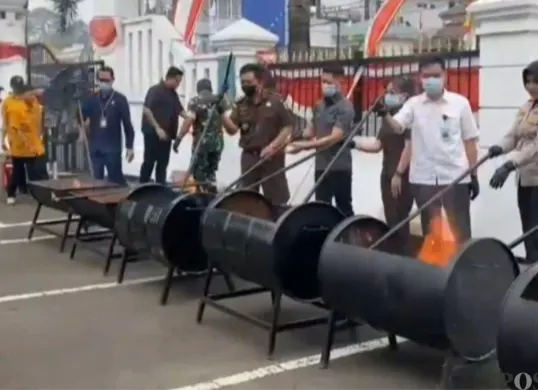 Kejari Kabupaten Pandeglang memusnahkan ribuan rokok ilegal dan barang bukti lain dari 41 perkara telah berkekuatan hukum tetap di halaman PN Pandeglang, Selasa, 18 Agustus 2026. (Sumber: Poskota/Samsul Fatoni)