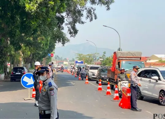 Petugas Dishub Kota Cimahi mengatur lalu lintas di kawasan Jalan Dustira, Kamis, 20 Agustus 2026. (Sumber: Poskota/Gatot Poedji Utomo)