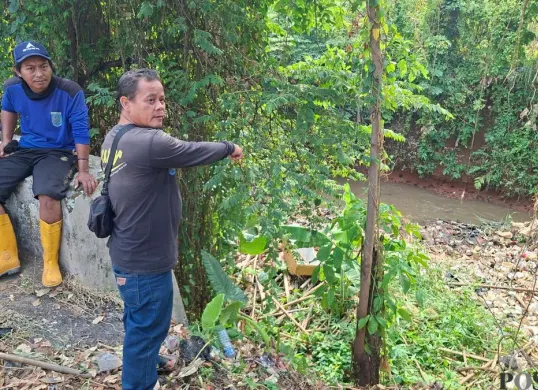 Petugas berada di tempat penemuan potongan tubuh korban mutilasi di Kali Cabang Barat, Jalan Raya Grogol, Kelurahan Grogol, Kecamatan Limo, Kota Depok, Jawa Barat. (Sumber: Poskota/Angga Pahlevi)