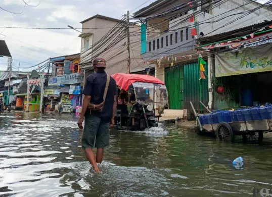 Warga Muara Angke, Jakarta Utara terobos banjir rob untuk beraktivitas. (Sumber: Pos Kota/ Ali Mansur)