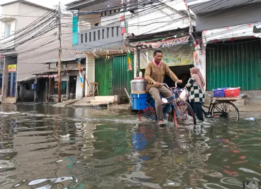 Warga Muara Angke, Jakarta Utara terobos banjir rob untuk beraktivitas. (Sumber: Pos Kota/Ali Mansur)