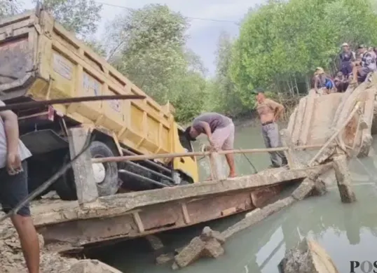 Mobil truk pengangkut pasir terperosok ke sungai saat melintasi jembatan di Kampung Citoke, Desa Mekarsari, Kecamatan Panimbang, Kabupaten Pandeglang. (Sumber: Pos Kota/ Samsul Fatoni)