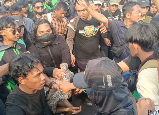 Seorang pria diamuk massa aksi unjuk rasa di depan gedung DPR RI, Senayan, Tanah Abang, Jakarta Pusat, Kamis, 27 Agustus 2026. (Sumber: Poskota/Ali Mansur)