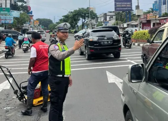 Petugas Polres Metro Depok mengawal perbaikan jalan rusak di wilayah Pancoran Mas, Kota Depok, Senin, 2 Februari 2026. (Sumber: Dok. Polres Metro Depok)