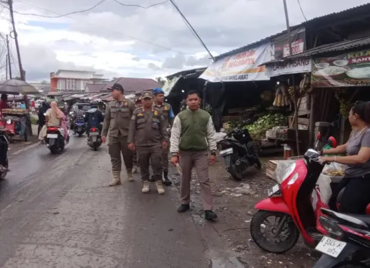Anggota Satpol PP saat melakukan pendataan bangunan dan pelaku usaha yang berada di garis sempadan jalan sekitar bekas Tempat Pembuangan dan Pengolahan Sampah (TPPS) Pasar Cisoka, Kecamatan Cisoka. (Sumber: Poskota/Veronica)