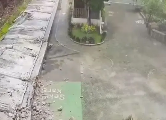 Sebuah tembok pembatas rumah warga di kawasan Kalibata, Jakarta Selatan, roboh hingga masuk ke area SMPN 182 Kalibata pada Minggu, 15 Februari 2026. (Sumber: Istimewa)