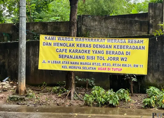Spanduk penolakan warga terkait adanya aktivitas hiburan malam di gubuk-gubuk pinggir Tol JORR W2. (Sumber: Poskota/Pandi Ramedhan)