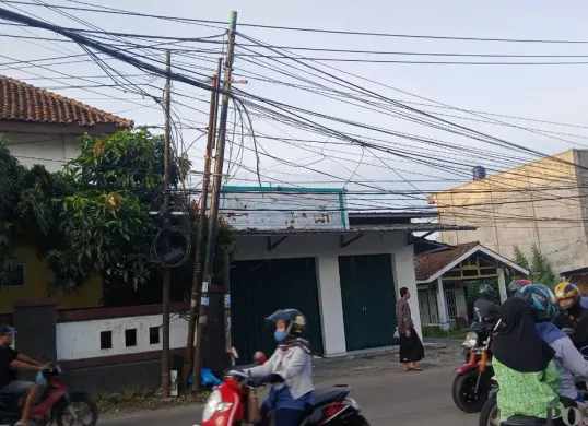 Kondisi kabel semrawut dan menjuntai di Jalan Raya Tigaraksa-Citeras tepatnya pertigaan Sekolah Dasar Negeri (SDN) III. (Sumber: Poskota/Veronica Prasetio)
