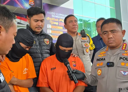 Petugas Polresta Tangerang menghadirkan tersangka penadah ponsel hasil kejahatan dalam konferensi pers pengungkapan kasus pembunuhan karyawan konter HP di wilayah Jambe, Kabupaten Tangerang. (Sumber: Poskota/Veronica Prasetio)
