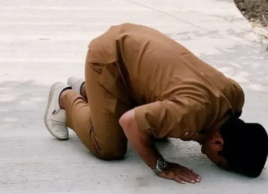Kepala Desa Karyajaya, Kecamatan Cimarga, Lebak, Jaeni saat sujud di atas jalan yang baru dibangun. (Sumber: Istimewa)