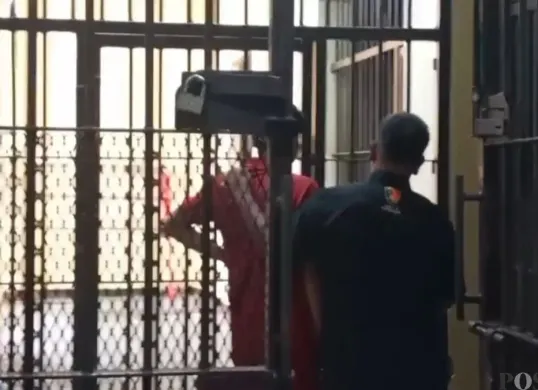 Kenakan baju orange, seorang Kades di Pandeglang saat dimasukan ke sel tahanan Polres Pandeglang. (Sumber: Poskota/Samsul Fatoni)