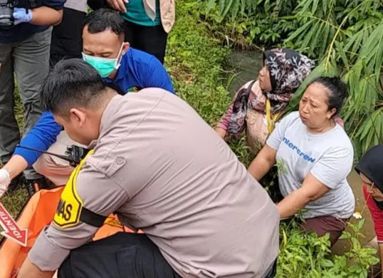 Anggota Bhabinkamtibmas Desa Tajurhalang, Aipda Dika bersama Tim Inafis dan Dokkes Polres Metro Depok melakukan olah TKP temuan jasad bayi di kolam empang warga. (Sumber: Dok. Polsek Tajurhalang)