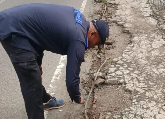 Petugas teknisi PJU Dinas Perhubungan Kota Depok sedang memperbaiki kabel tanam PJU di Jalan Raya Bogor, konslet hingga mengeluarkan asap putih. (Sumber: Dok. Polsek Cimanggis)