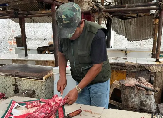 Pedagang daging sapi di Pasar Cakung, Jakarta Timur, Suryadi mencincang barang jualannya, Kamis, 22 Januari 2026. (Sumber: Poskota/M. Tegar Jihad)