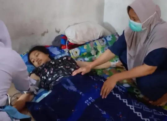 Bidan saat melakukan pengecekan kesehatan seorang ibu setelah proses melahirkan. (Sumber: Istimewa)