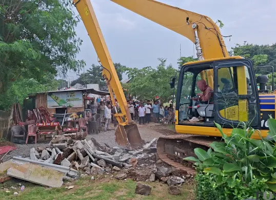 Alat berat jenis beko membongkar pagar pembatas yang dibangun di kawasan bibir Setu Tujuh Muara, Sawangan, Kota Depok. (Sumber: Poskota/Angga Pahlevi)