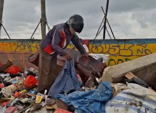Warga mengais barang dari tumpukan sampah yang hendak dibuang ke Bantar Gebang di kawasan Cengkareng, Jakarta Barat, Senin, 26 Januari 2026. (Sumber: Poskota/Pandi Ramedhan)