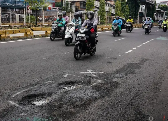 Pengendara melintasi jalanan berlubang di Jalan Palmerah, Mampang Prapatan Raya, dan Gatot Subroto, Jakarta, Rabu, 28 Januari 2025. (Sumber: Poskota/Bilal Nugraha Ginanjar)