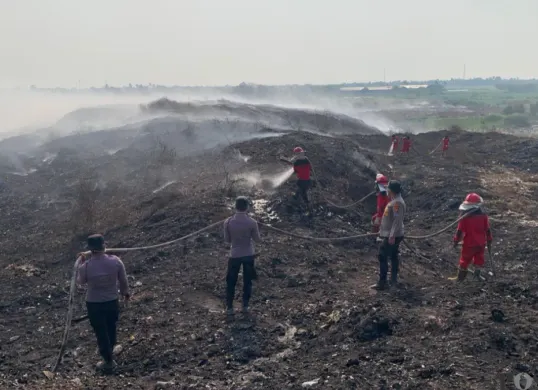 Petugas gabungan saat memadamkan api di TPA Jatiwaringin. (Sumber: Poskota/Veronica)