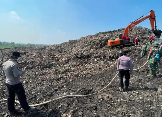Petugas gabungan saat memadamkan kebakaran TPA Jatiwaringin Kecamatan Sukadiri, Kabupaten Tangerang. (Sumber: Poskota/Veronica Prasetio)