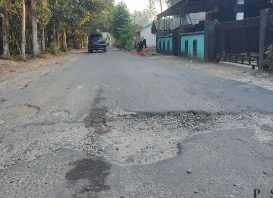 Ruas jalan Bama-Pagelaran di Pandeglang yang dibangun melalui program Bang Andra terlihat sudah rusak lagi. (Sumber: Poskota/Samsul Fatoni)
