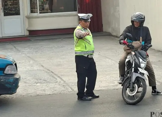 Polisi mencegat pemotor nakal yang berkendara lawan arah di Jalan Raya Bogor KM 35, Kelurahan Sukamaju, Kecamatan Sukmajaya, Kota Depok, Senin, 20 Juli 2026. (Sumber: Poskota/Angga Pahlevi)