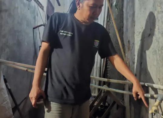 Ketua RW 15, Arif Afifullah menunjukan kran air di rumahnya saat musim kemarau serta wilayahnya yang mengalami kekeringan. ( (Sumber: Poskota/Angga)