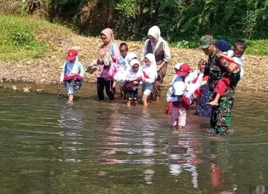 Para siswa SD di Desa Padahayu, Kecamatan Cikedal, Pandeglang, saat hendak menyebrangi sungai menuju sekolah. (Sumber: Poskota/Samsul Fatoni)