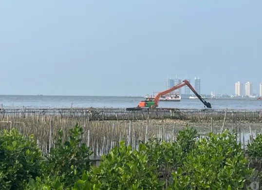Alat berat berupa eksavator sedang mengeruk sampah di perairan Teluk Jakarta tepatnya perairan Muara Angke, Penjaringan, Jakarta Utara, Kamis, 4 Juni 2026. (Sumber: Poskota/ Pandi Ramedhan)