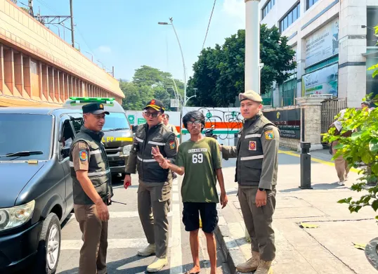 Sony, 32 tahun, diamankan Satpol PP DKI Jakarta saat mengatur arus kendaraan di kawasan pertigaan Cikini, Jakarta Pusat, Senin (8/6/2026). (Sumber: Poskota | Foto: M. Tegar Jihad)