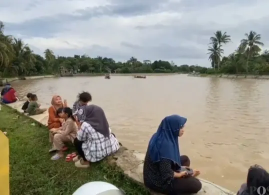 Warga ngabuburit di kawasan Situ Cilembun di Desa Selaraja, Kecamatan Warunggunung, Kabupaten Lebak. (Sumber: Poskota/Samsul Fatoni)