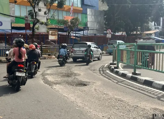 Ruas jalan yang berada persis di depan Pasar Palmerah Kelurahan Gelora Kecamatan Tanah Abang, Jakarta Pusat, terlihat berlubang, Minggu, 8 Maret 2026. (Sumber: Poskota/Pandi Ramedhan)