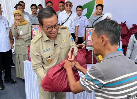 Gubernur Jakarta Pramono Anung saat memberikan sembako murah kepada salah satu warga di Balai Kota DKI Jakarta, Senin, 9 Maret 2026. (Sumber: Poskota/M. Tegar Jihad)