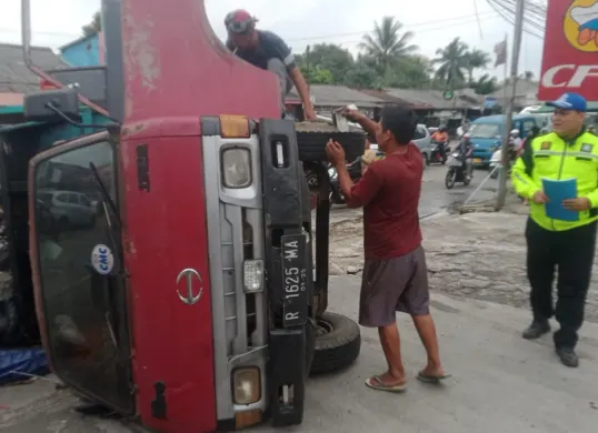 Truk pengangkut sampah terguling di Jalan Raya Jampang, Kecamatan Kemang Kabupaten Bogor, Senin 9 Maret 2026, karena sopir hilang kendali. (Sumber: Satlantas Polres Bogor)