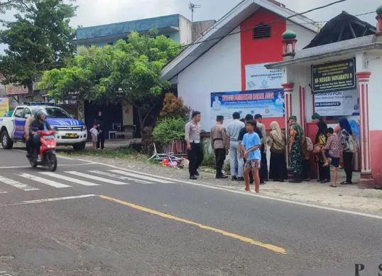 Anggota Polisi dari Polres Pandeglang, saat melakukan pemeriksaan lokasi kejadian laka lantas di depan SDN Sukaratu 5. (Sumber: Poskota/Samsul Fatoni)
