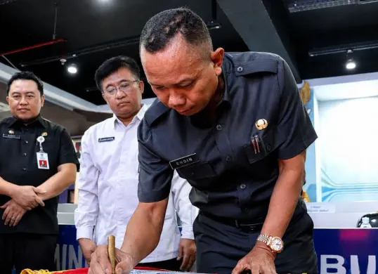Sekda Kabupaten Bekasi, Endin Samsudin menandatangani Piagam Pencanangan Program Desa Cantik di Ruang Command Center Diskominfosantik Kabupaten Bekasi, Selasa, 12 Mei 2026. (Sumber: Dok. Diskominfosantik Kabupaten Bekasi)