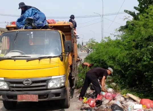 Petugas mengangkut sampah liar di kawasan Exit Tol Gabus, Kecamatan Tambun Utara, Kabupaten Bekasi. (Sumber: Dok. Diskominfosantik Kabupaten Bekasi)