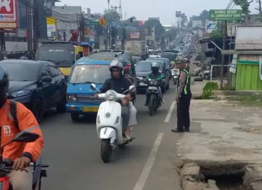 Polantas Polsek Bojongsari dalam mengurai kemacetan parah di Jalan Raya Parung - Ciputat, akibat adanya truk terguling, Minggu, 4 Oktober 2026. (Sumber: Polsek Bojongsari)