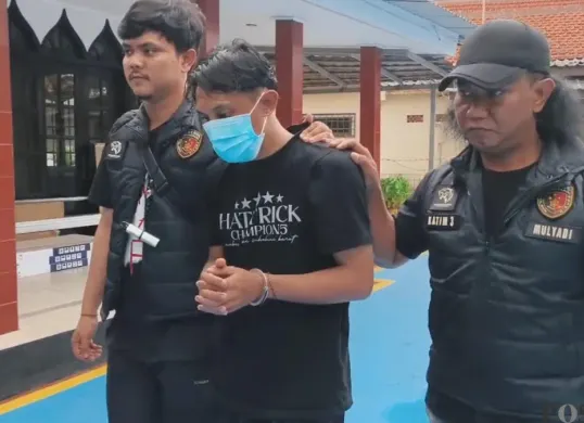 Tersangka MIM saat diamankan oleh penyidik. (Sumber: Poskota/Veronica)