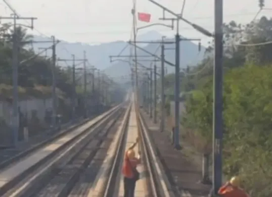 Potret petugas saat membersihkan layang-layang yang tersangkut di jalur Kereta Cepat Whoosh. (Sumber: KCIC)