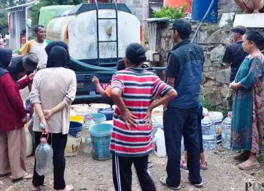 Petugas Perumda Air Minum Tirta Raharja membagikan air bersih kepada pelanggan di sejumlah wilayah di Bandung Raya. (Sumber: Poskota/Gatot Poedji Utomo)