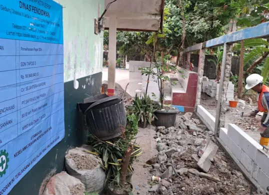 Petugas sedang memperbaiki tembok sekolah SDN 03 Tapos yang ambruk. (Sumber: Poskota/Angga)