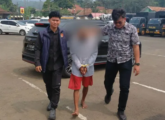 Personel Polres Pandeglang menggiring pelaku pencabulan anak tiri di Kecamatan Carita. (Sumber: Dok. Istimewa)