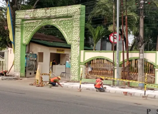 Sejumlah pekerja menyelesaikan pembangunan dan perbaikan trotoar di depan kawasan Masjid Al-Ittihad, Jumat, 16 Oktober 2026. (Sumber: Poskota/ Rizki Gojali)