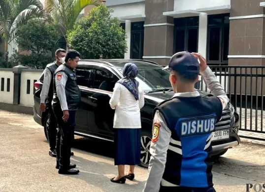 Petugas Dinas Perhubungan Kota Bekasi menegur pegawai Pemkot Bekasi yang masih memarkirkan kendaraannya di pinggir jalan saat penataan parkir mulai diberlakukan, Senin, 19 Oktober 2026. (Sumber: Poskota/Dini Aghnny Khoiriyah)