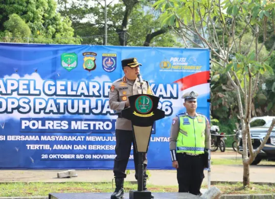 Kapolres Metro Depok, Kombes Pol Christian Rony Putra menyematkan pita Operasi Patuh Jaya 2026 ke perwakilan anggota gabungan di saat Apel Gelas Pasukan Operasi Patuh Jaya 2026 di Mapolres Metro Depok. (Sumber: Polres Depok)
