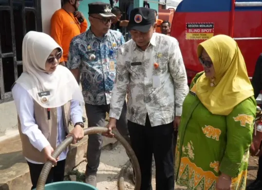 Bupati Pandeglang, Raden Dewi Setiani membantu penyaluran air bersih kepada warga terdampak kekeringan. (Sumber: Dok. BPBD Pandeglang)