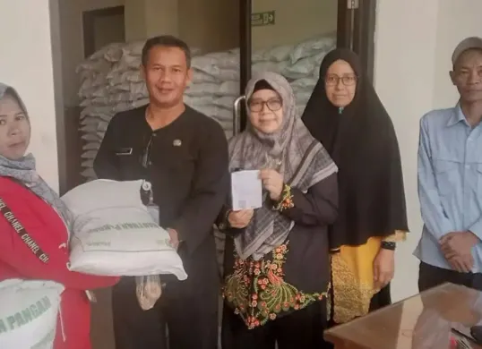 Lurah Rangkapan Jaya, Agus Riyan Herdyana menyerahkan bantuan pangan beras 30 kg ke warga di Kelurahan Rangkapan Jaya, Kecamatan Pancoran Mas, Kota Depok. (Sumber: Dok. Istimewa)