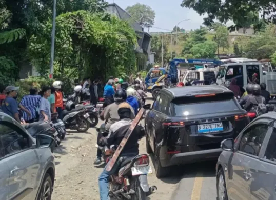 Situasi lalu lintas di Jalan Raya KSU (Pondok Gurame) padat merayap setelah mobil elf dari dalam Kali Cikumpa berhasil di evakuasi. (Sumber: Satlantas Polsek Sukmajaya)